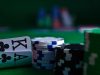 Close-up of playing cards and poker chips on a green felt casino table