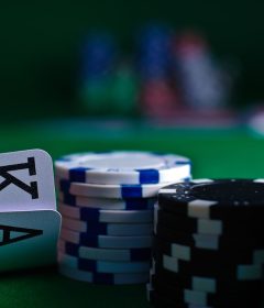 Close-up of playing cards and poker chips on a green felt casino table