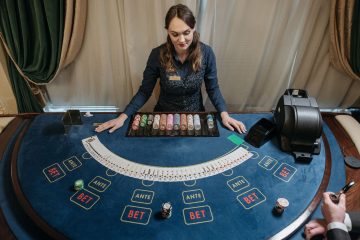 Professional female casino dealer managing a gaming table with chips and cards in a luxurious setting. — 10 Best Real Funds O