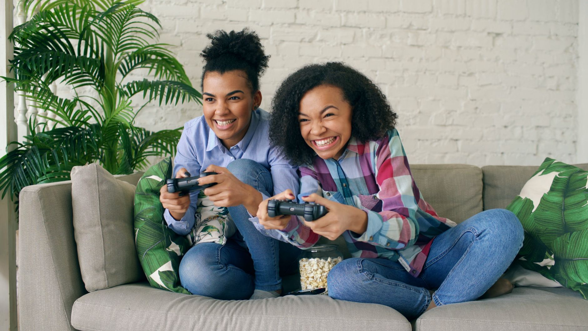 Two teenagers enjoying video games on a couch, showing excitement and joy. — agua bacteriostatica precio 5
