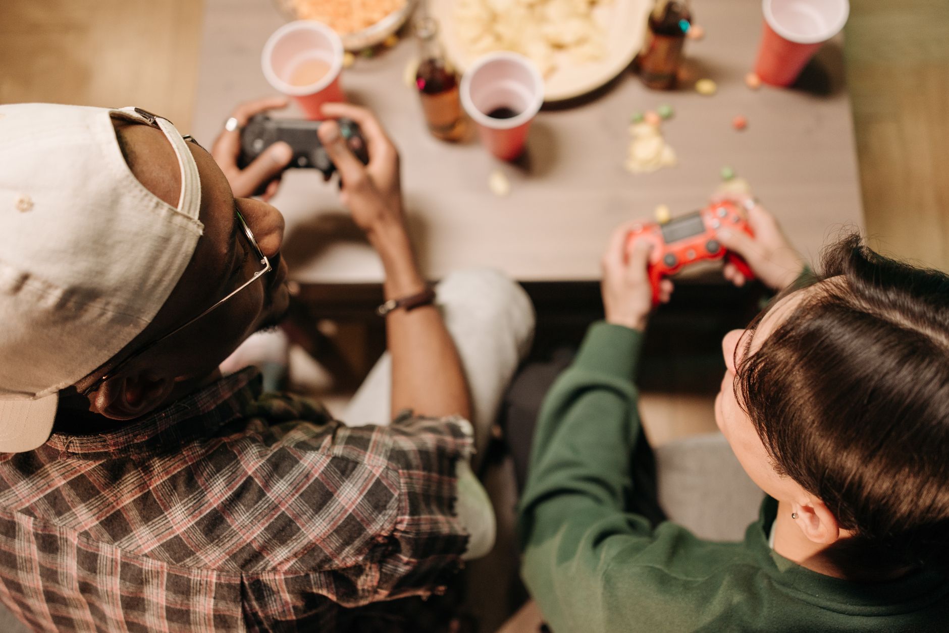 Two friends playing video games with controllers, sharing a fun indoor experience. — Begin Your Baccarat Journey with Style a
