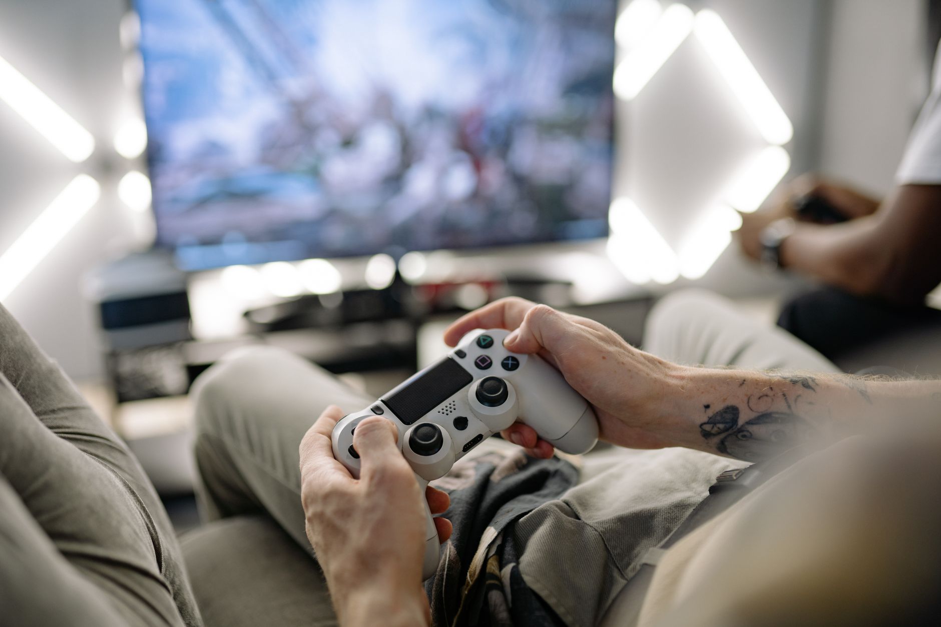 Hands holding a video game controller in a modern living room, playing on TV. — "Casino Live: Gioca In Diretta Live Que Inclu