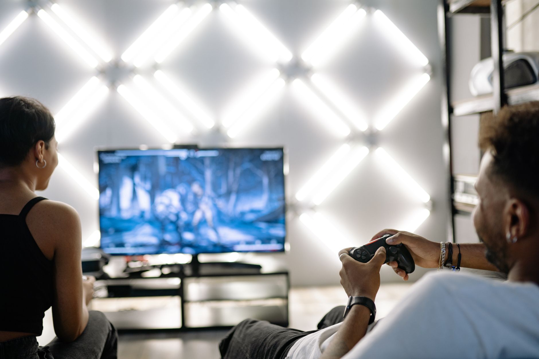 Two adults are having fun playing video games in a stylish, modern living room with LED lighting. — Casino Uden Rofus 2024onl