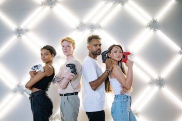 Four diverse friends posing confidently with game controllers against a modern LED backdrop. — Comentarios sobre la Trembolon