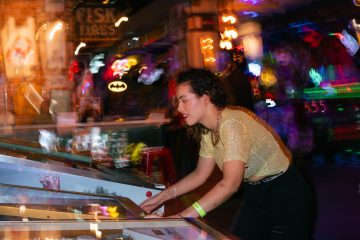 Young woman enjoying a night out playing pinball in an energetic arcade setting. — Cut Stack 150 mg: Erfahrungen und Kommenta