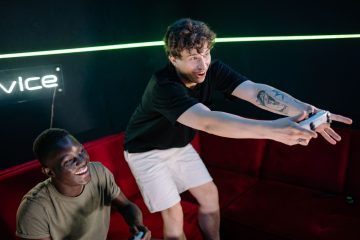 Two young men having fun playing video games in a cozy indoor setting. — How Slot5000 Ensures a Safe and Seamless Betting Exp