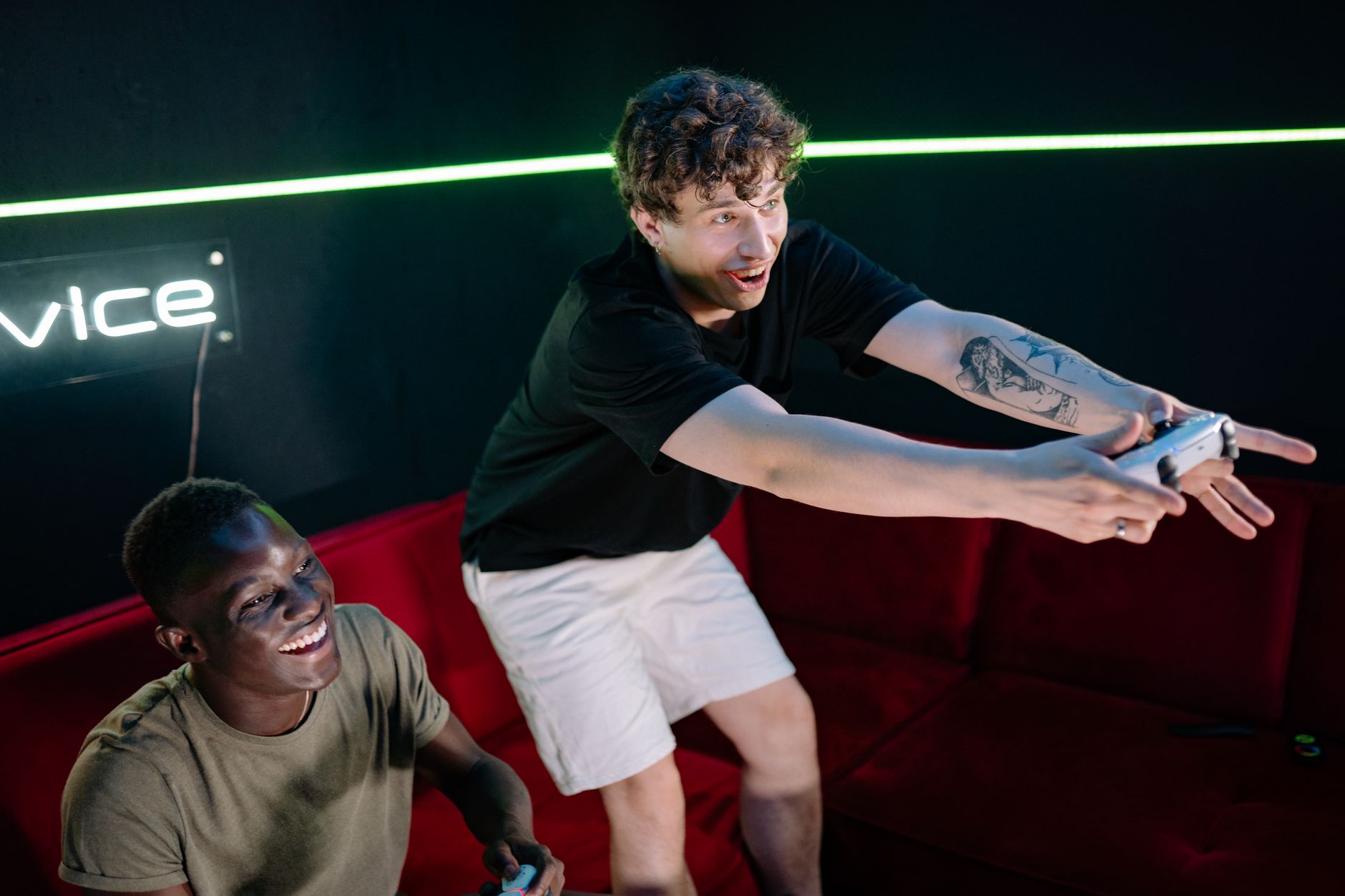 Two young men having fun playing video games in a cozy indoor setting. — How Slot5000 Ensures a Safe and Seamless Betting Exp