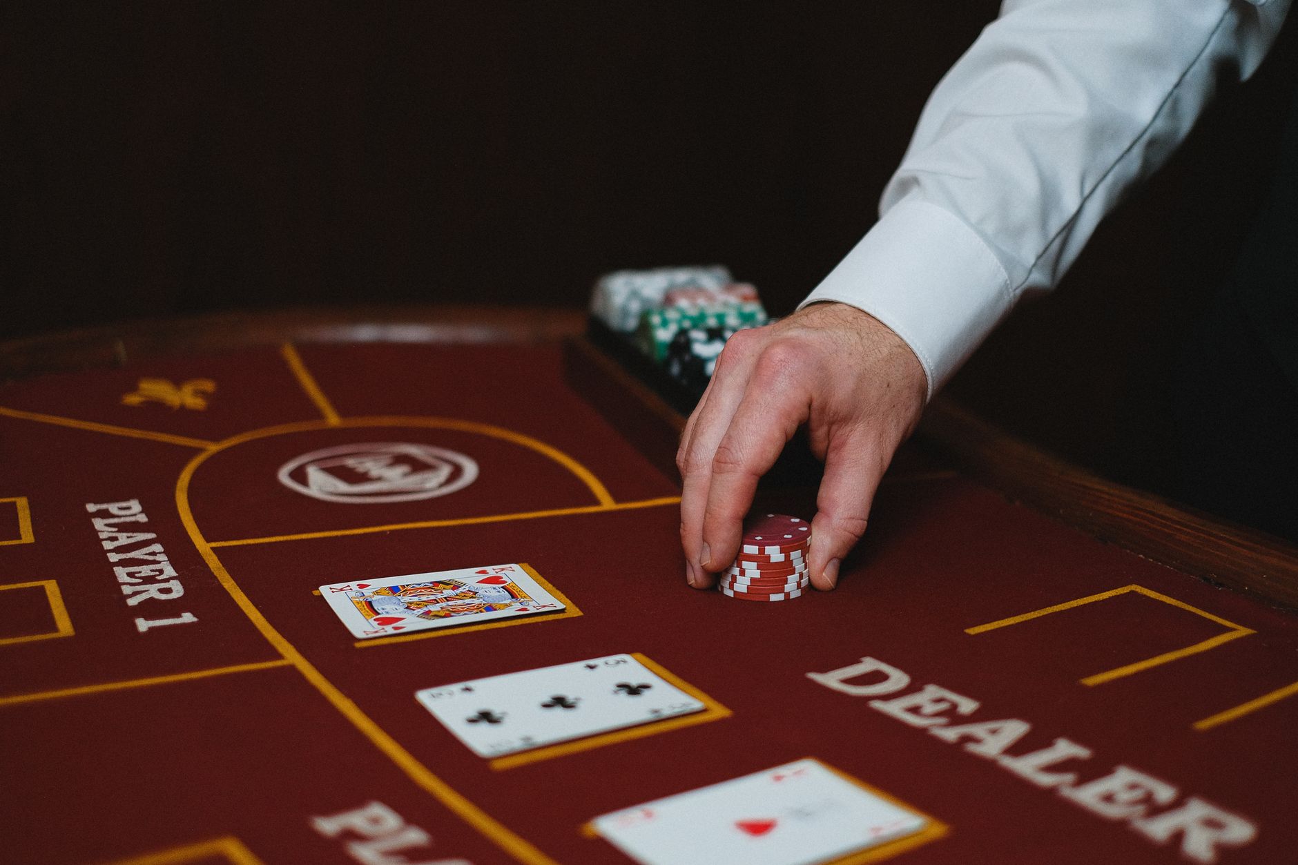 Close-up of a dealer handling poker chips on a casino table, showcasing cards and layout. — "Ideal Online Casinos Throughout