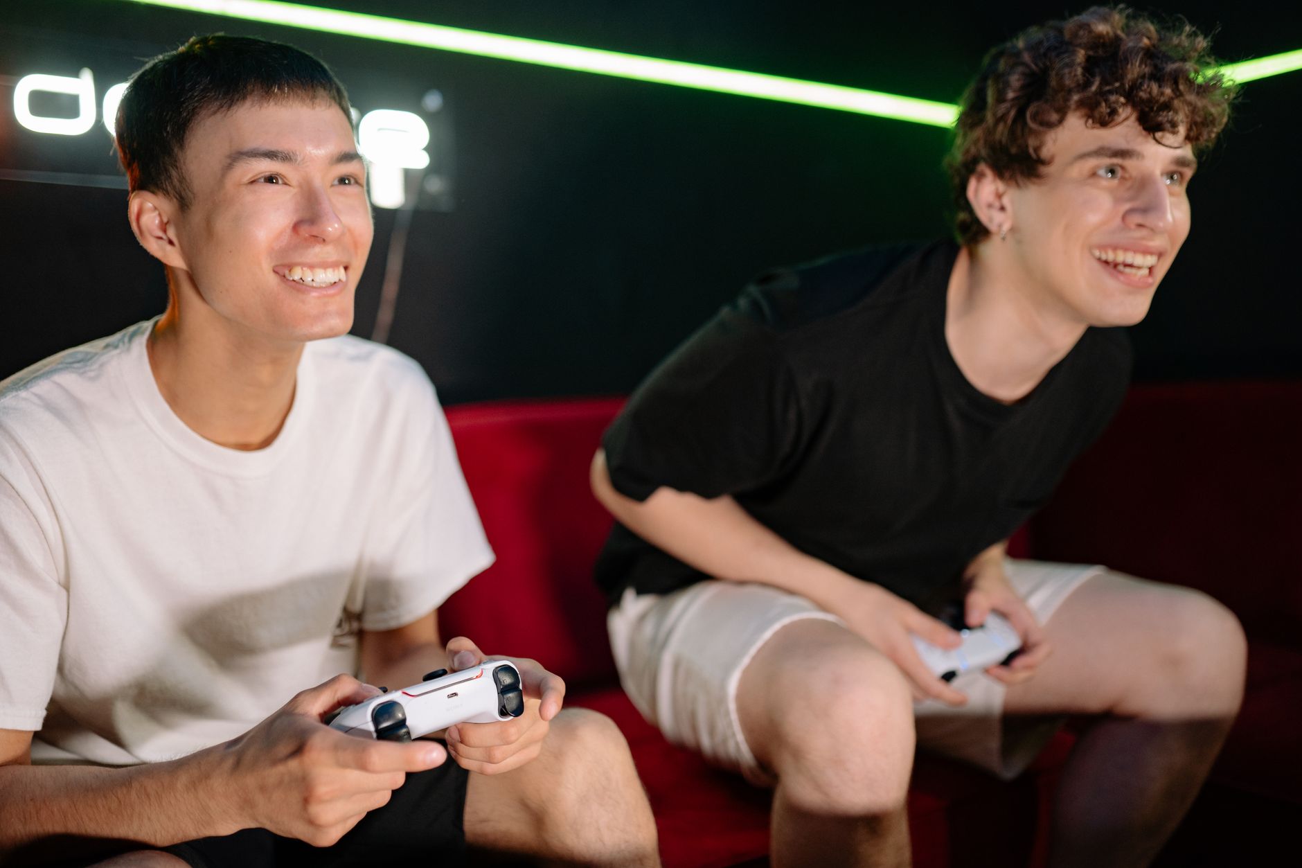 Two friends having fun playing video games indoors, captured in a lively and engaging moment. —