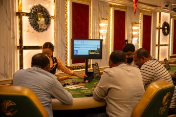 A group of adults playing at a casino table in Goa, India, captured indoors with festive decor. —