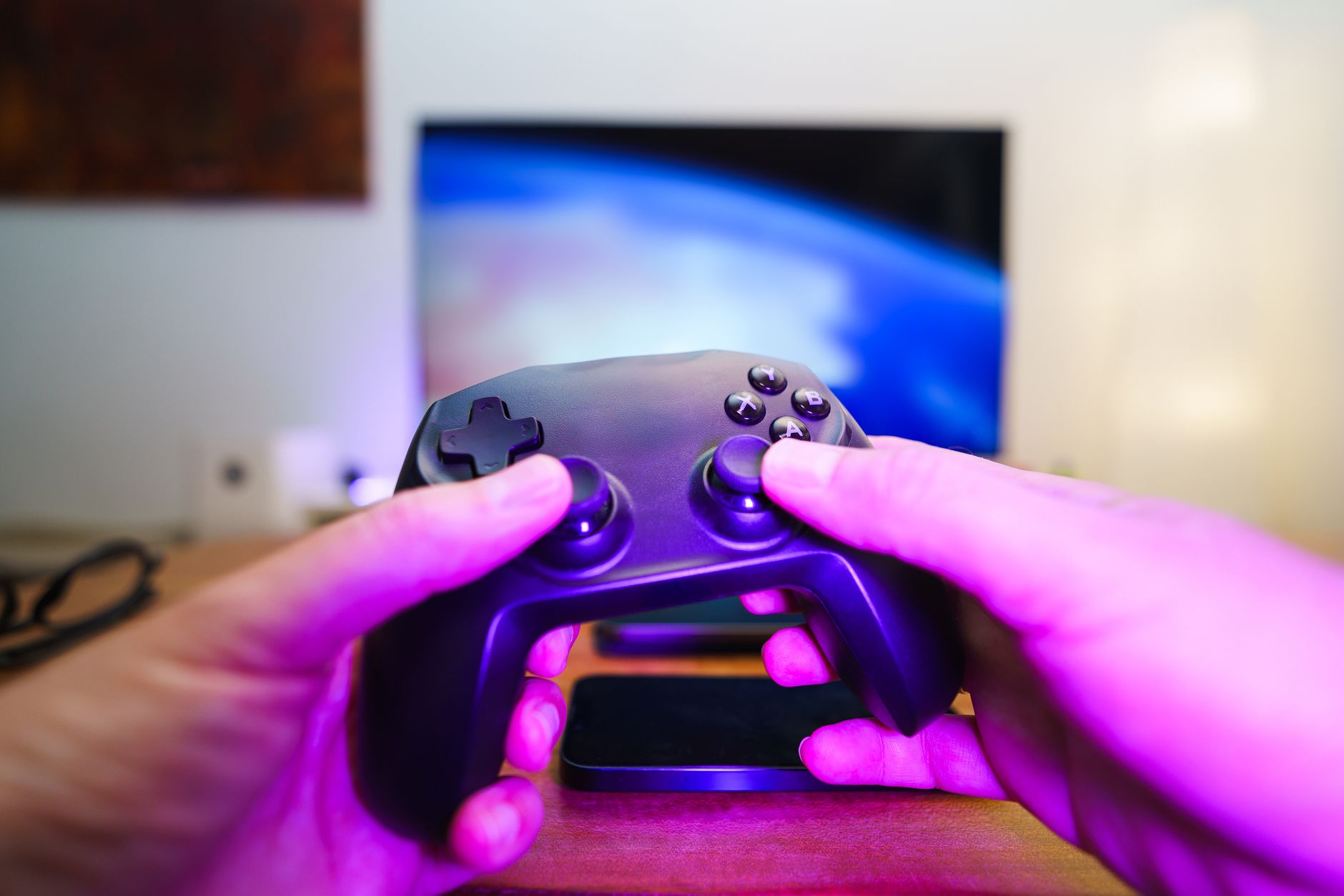 Close-up of hands holding a game controller in front of a TV screen. Perfect for entertainment setups. — Maximizing Bonuses a
