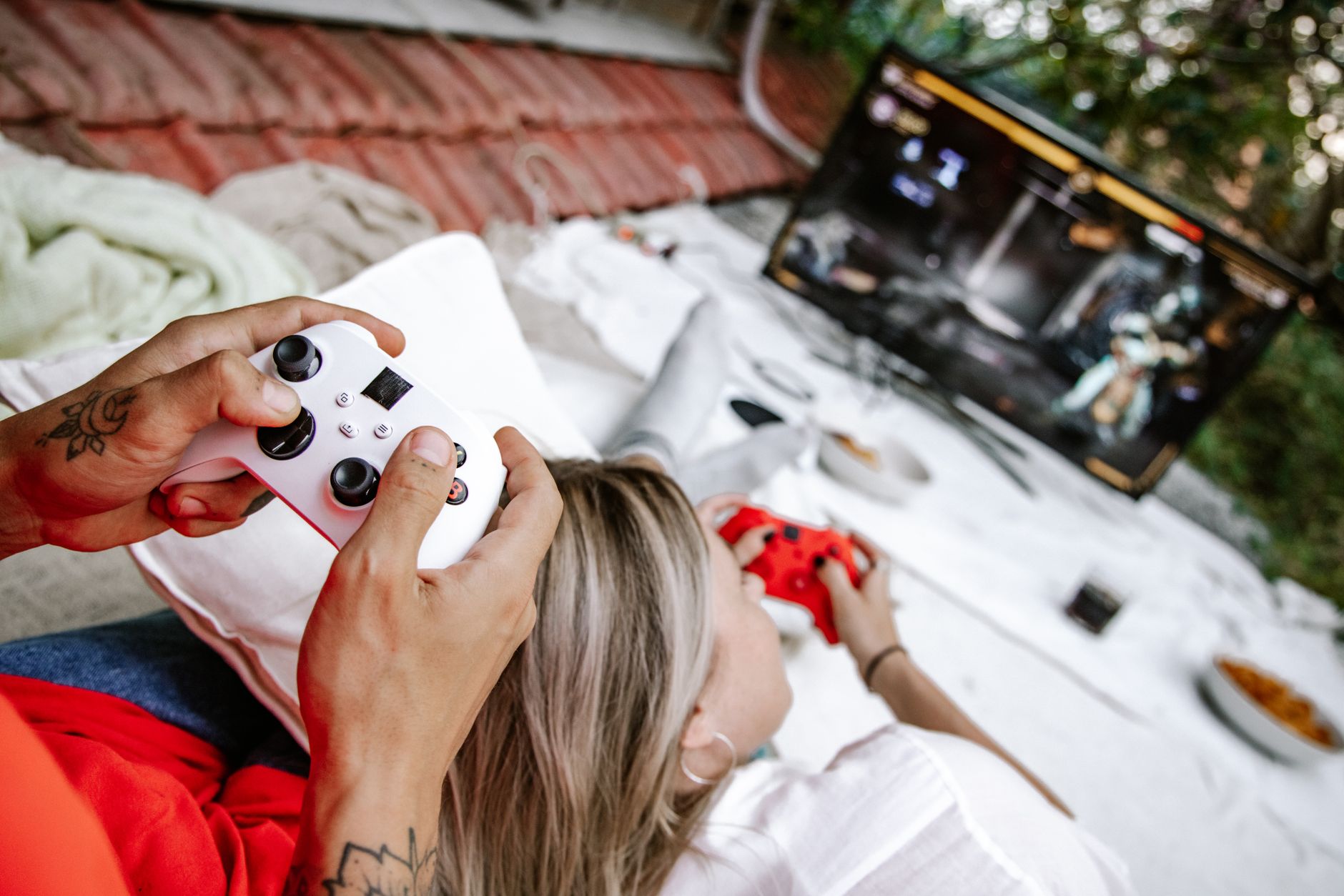 A couple playing video games outdoors, focusing on the controllers and screen. — Top Free Spins No Deposit Bonuses For 2025 W