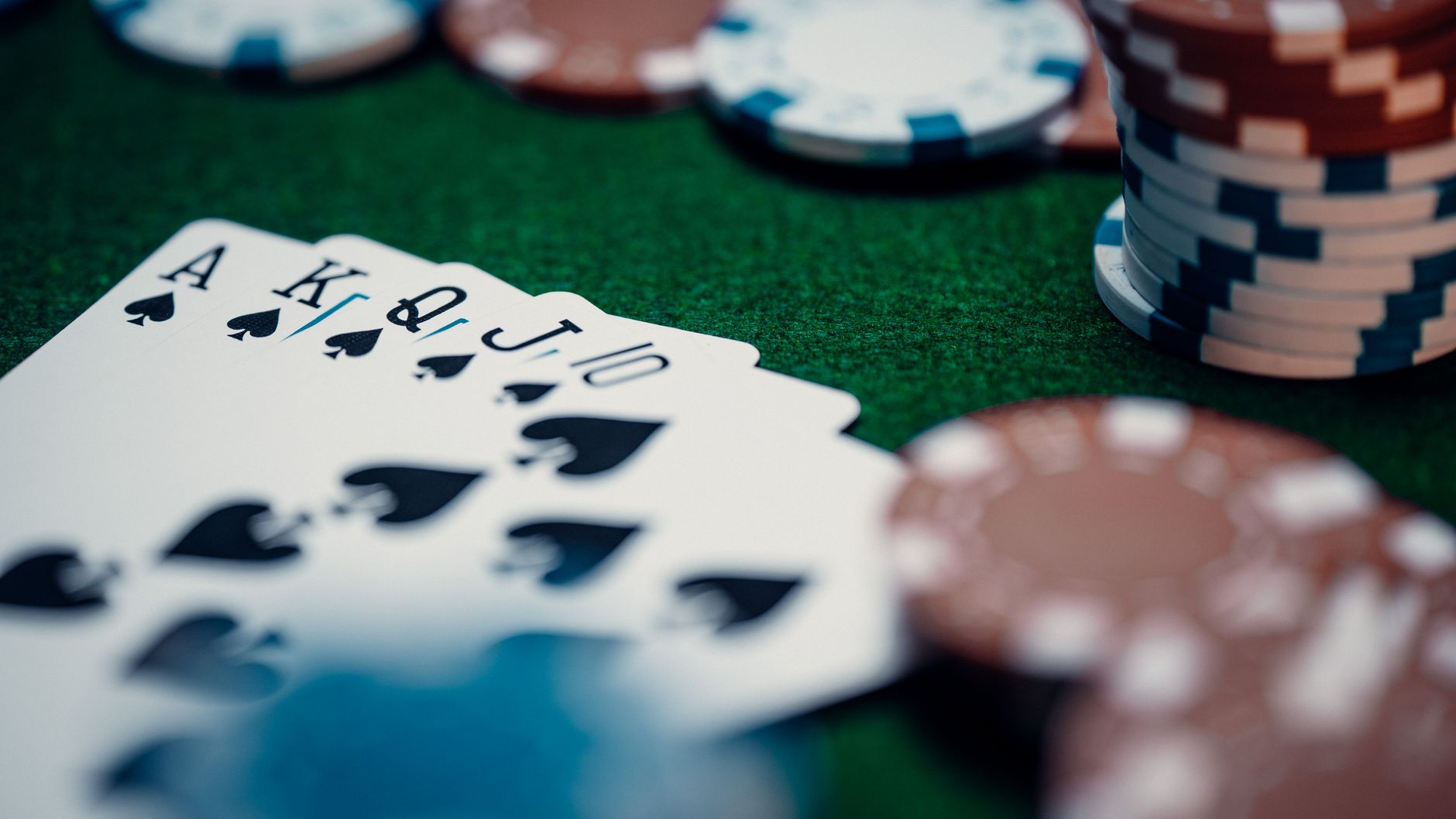 Close-up of a royal flush poker hand surrounded by colorful chips on a green table. — Top Internet Casino Bonuses For 2025 Cl