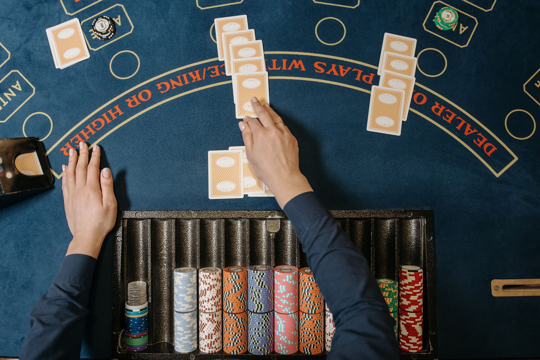 Dealer hands distributing cards at a casino blackjack table with chips in view. — Top Online Casinos North America In 2025 Re