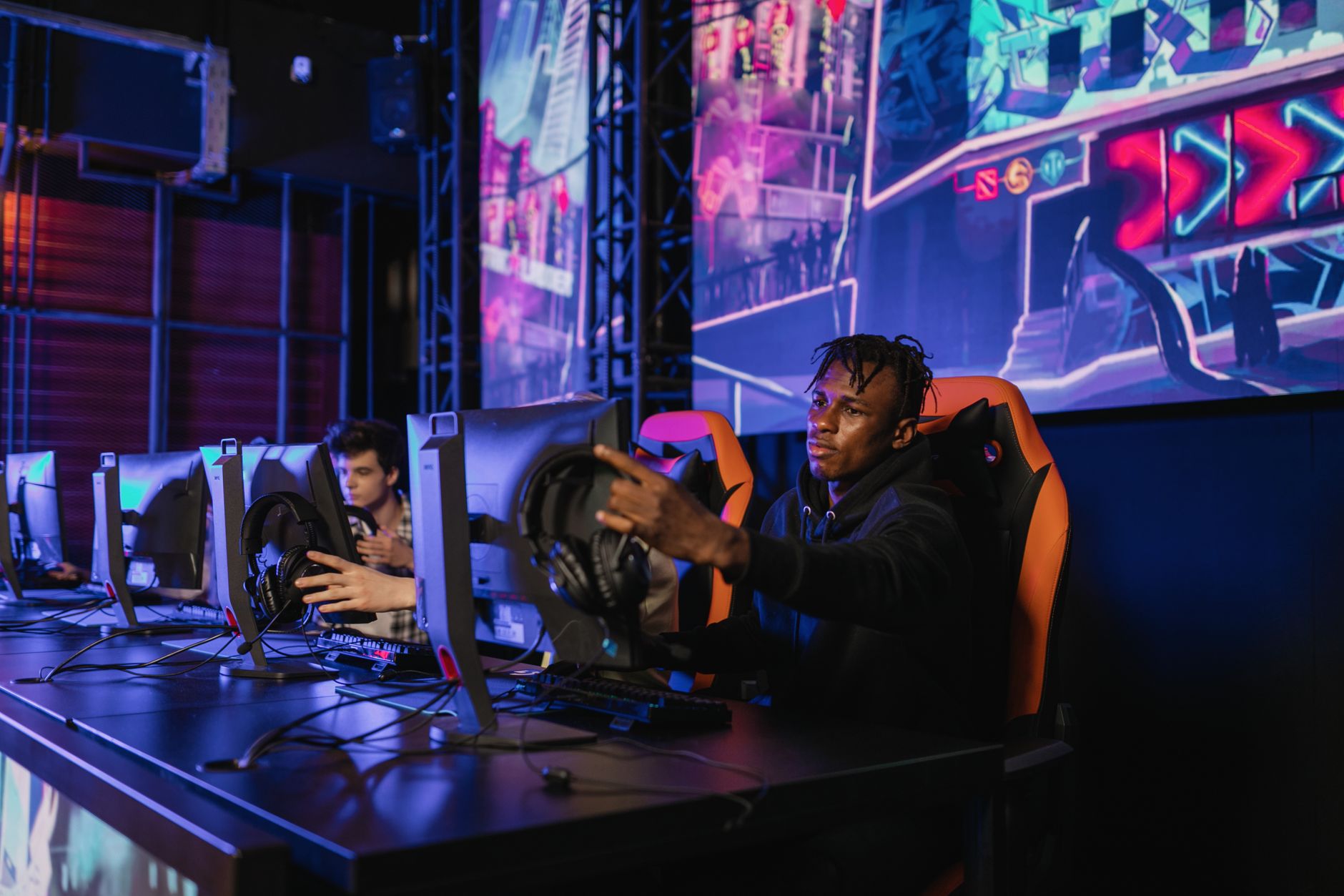 Two gamers intensely focused in a professional eSports competition with vibrant game visuals. — Why Casino Plus Offers More E
