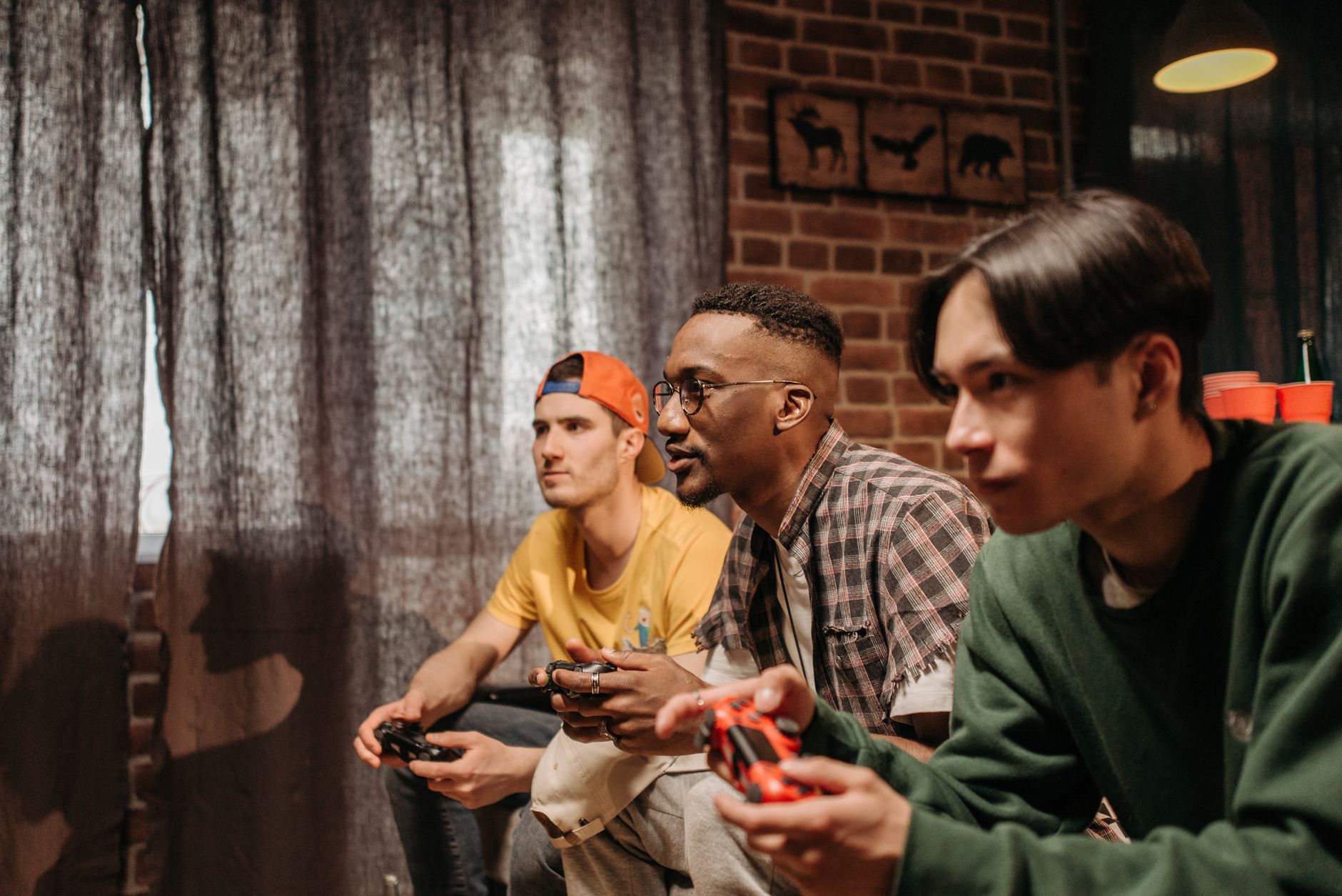 Three men focused on playing video games with controllers indoors. — XML-RPC Test Post