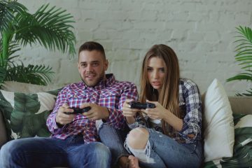 Young couple playing video games intensely on a couch, enjoying leisure time indoors. — XMLRPC Test Post