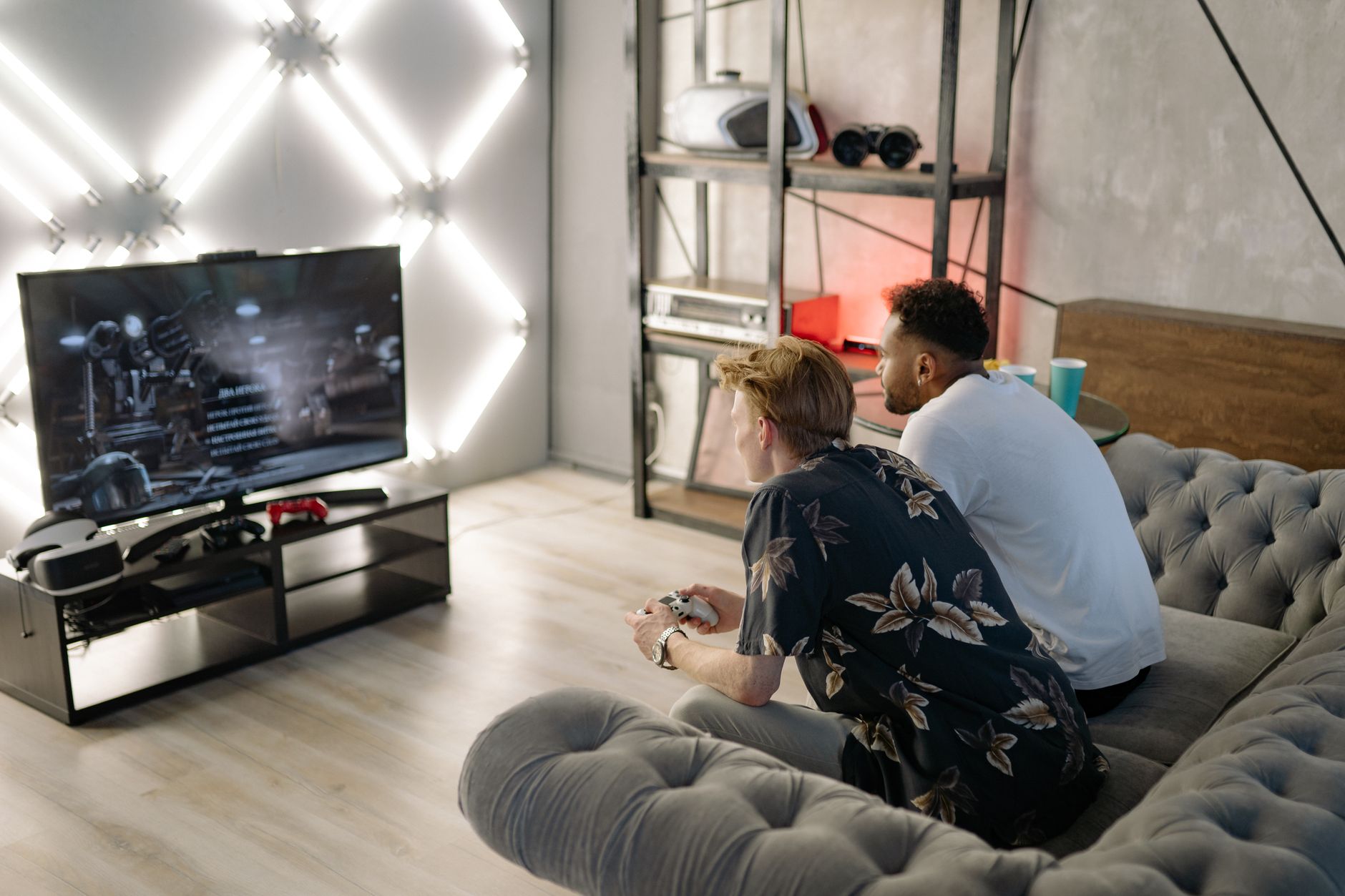 Two young men gaming together in a stylish modern living room with a large TV. — Yesbet’s Live Casino & Slot Machines: Endles