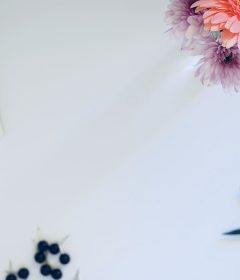 Top view of a workspace with a keyboard, flowers, and small tools